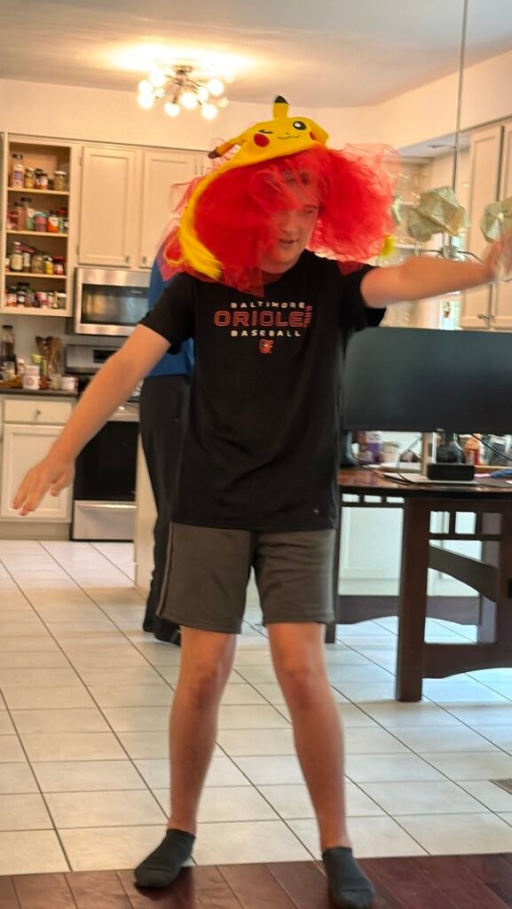A camper in a colorful hat at Improv & Sketch Comedy Camp